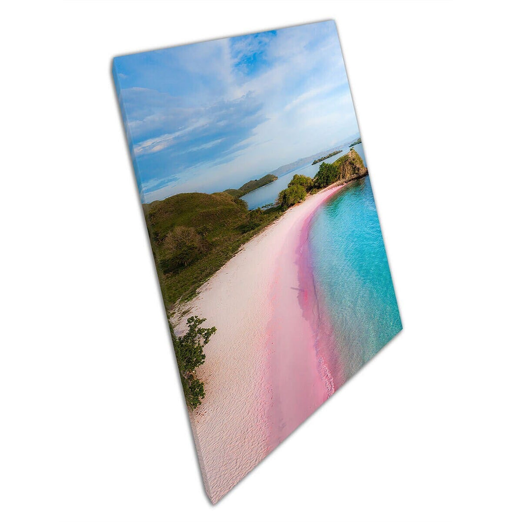 Dromerig roze zandstrand met serene oceaan omringd door rijke groene gebladerte muurkunstafdruk op canvas gemonteerde canvas print